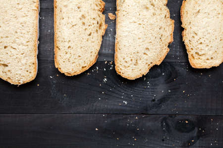 Bread slices on black wooden tableの写真素材