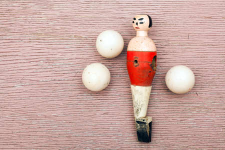 Vintage wooden ball player and white balls on cracked vintage wooden background