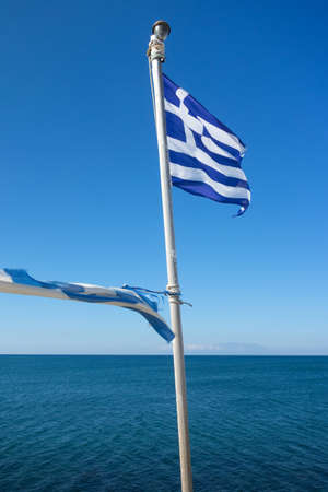 Greece flag waving in the wind over blue sky の写真素材