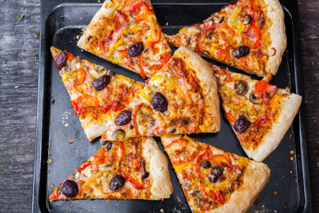 Sliced home made pizza on wooden rustic background の写真素材