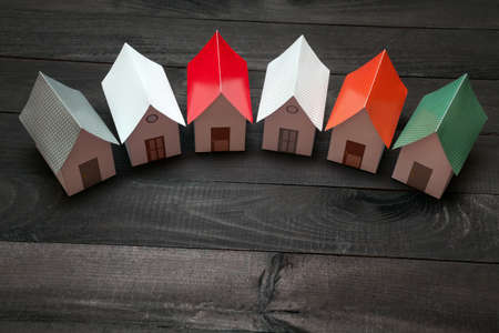 Papercraft Houses in a row on a dark wooden surfaceの写真素材