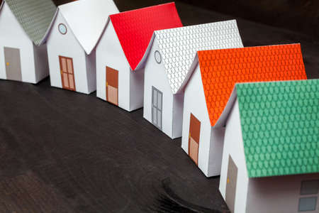 Papercraft Houses in a row on a dark wooden surfaceの写真素材