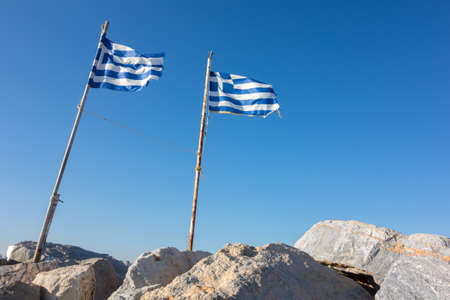 Greek flags waving against the blue skyの写真素材