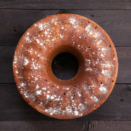 Fresh baked cake with chocolate on black wooden backgroundの写真素材