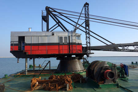 Old red and gray crane on tanker boatの写真素材