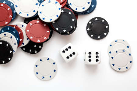Chips for poker and dice on white の写真素材