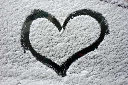 Heart symbol on snowy car glass.の写真素材