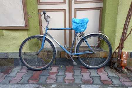 Old rusty vintage bicycle near the concrete wallの写真素材