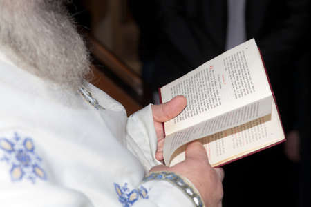 Orthodox priest reading a book of prayers in baptismの写真素材