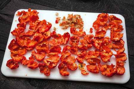 Red hot Trinidad moruga scorpion peppers chopped on white cutting Boardの写真素材