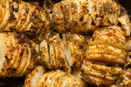 Hasselback potatoes in a baking dishの写真素材