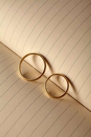 Wedding rings forming a heart onto a notebookの写真素材