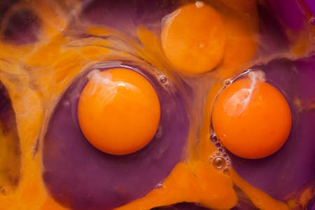Eggs in a purple bowl ready for mixingの写真素材