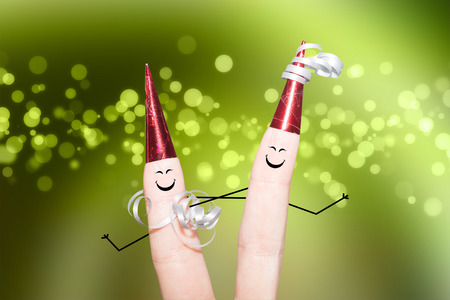 Two smiling women dancing on a party green backgroundの写真素材