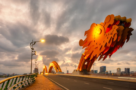 Danang Dragon bridge through Han river in Da Nang city in Vietnam. Dragon bridge at sunset which is a very famous destination for touristsの写真素材