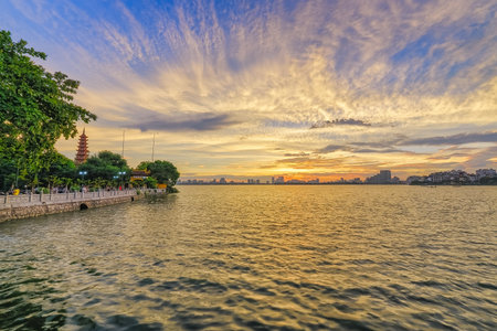 Tran Quoc Pagoda on West Lake in Hanoi, Vietnam, glows under a magnificent sunsetの写真素材
