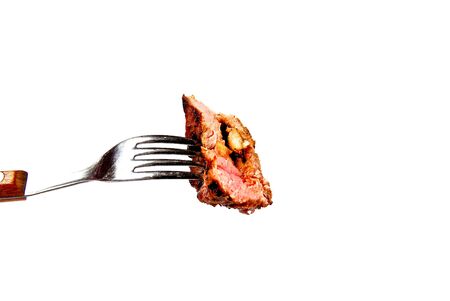 A piece of succulent steak on a fork ready to be eatenの写真素材