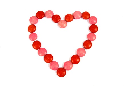 Red and pink candy in the shape of a chocolate heart on whiteの写真素材