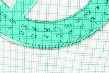Translucent green protractor on green striped graph paperの写真素材