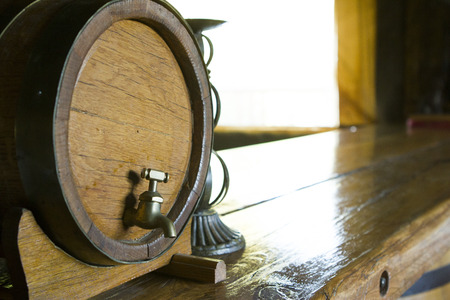 Antique wine barrel with natural light reflecting on a wooden surfaceの写真素材