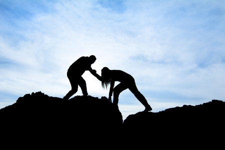 Silhouette of helping hand between two climber - Stock Imageの写真素材