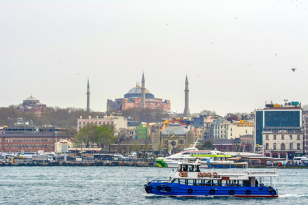 Istanbul, Turkey June 13, 2019: Muslim architecture and water transport in Turkey - Beautiful View touristic landmarks from Bosphorus. Cityscape of Istanbul at sunset - old mosque and turkish steamboats, view on Golden Hornのeditorial素材