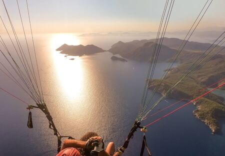 Extreme sport. Landscape. Paragliding in the sky. Paraglider tandem flying over the sea. in Oludeniz, Turkeyの写真素材