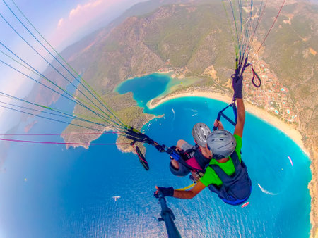 Paraglider tandem flying over the sea with blue water and mountains in bright sunny day. Aerial view of paraglider and Blue Lagoon in Oludeniz, Turkey. extreme sport. landscapeの写真素材