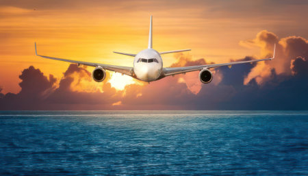 Airplane in the sky over the sea at sunset. Travel conceptの素材
