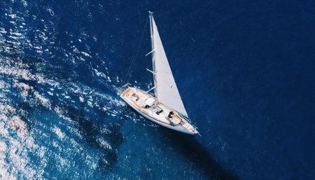 Aerial view of sailboat sailing in blue sea. Top view of luxury yachting boat.の素材