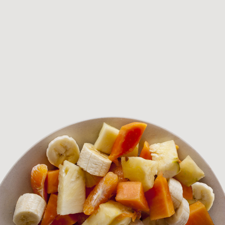 tropical fruit salad on a plate isolated on white backgroundの写真素材