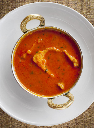 traditional indian fish in spicy gravy served in a metal potの写真素材