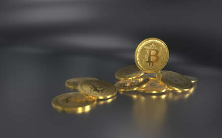 Gold bitcoin coins are lying on the table on a solid backgroundの写真素材