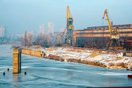 Old abandoned industrial docks and loading cranes in winter