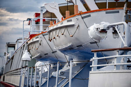 Lifeboats on a ship close-up against the background of thunderclouds
