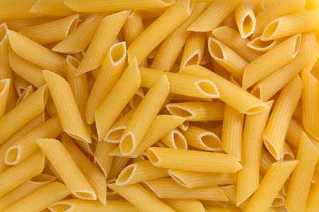 Macro closeup of uncooked italian pasta - penne background textureの写真素材