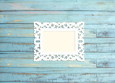 White Vintage picture frame, wood plated, blue wood background, clipping path includedの写真素材