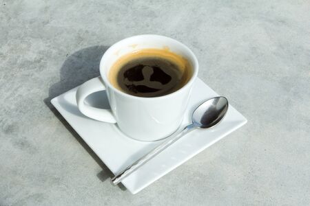 Cup of black coffee on Vintage or grungy white background of natural cement.の写真素材