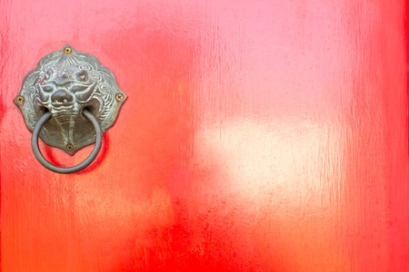 Red chinese door with a lion/dragon head.の写真素材