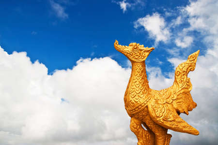 Golden buddhist bird on cloud blue skyの写真素材