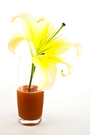 White lilies in glass of juice isolated on white background の写真素材