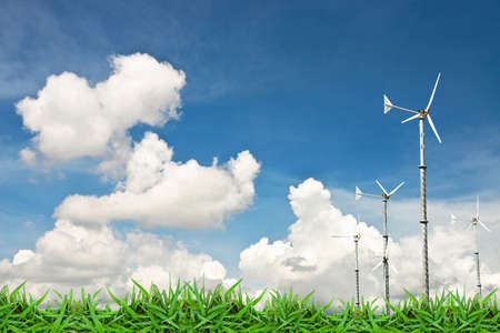 Turbine wind mill on green grass against cloud blue skyの写真素材