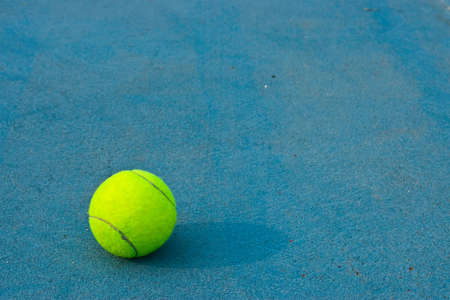 Tennis ball on blue court backgroundの写真素材