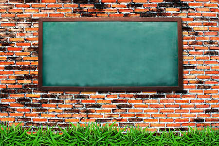 Chalkboard and green grass on grunge brick wallの写真素材