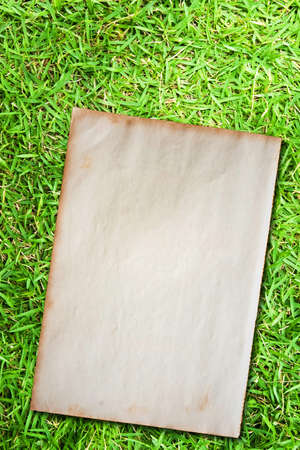 Grunge paper on green grass backgroundの写真素材