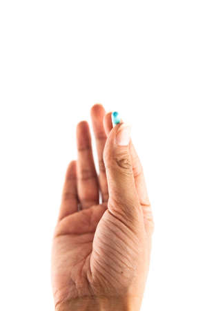 Hand holding a pill capsule, isolate on white backgroundの写真素材