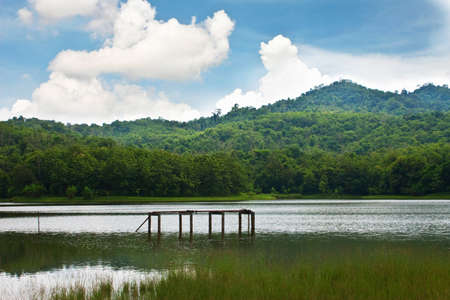 Pier in the lake against cloud blue sky and hillの写真素材