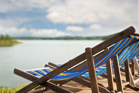 Closeup wood chair beside dam lakeの写真素材