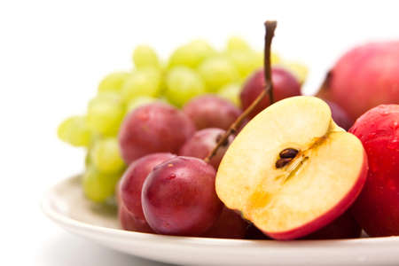 Apple and grape fruit on dish, isolate on white backgroundの写真素材