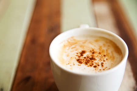 Shallow dept of field, a cup of coffee on wood backgroundの写真素材